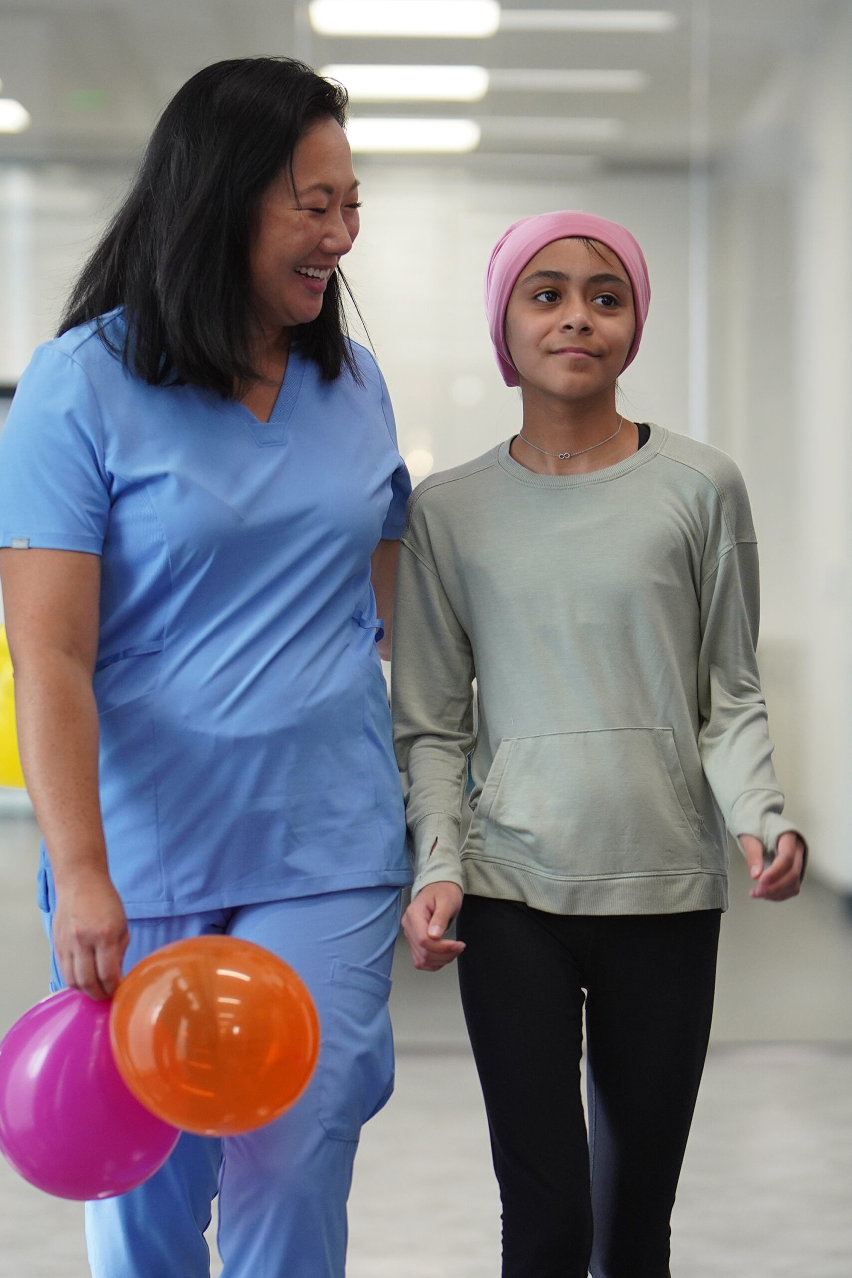Nurse walking with young girl who is going home after treatment