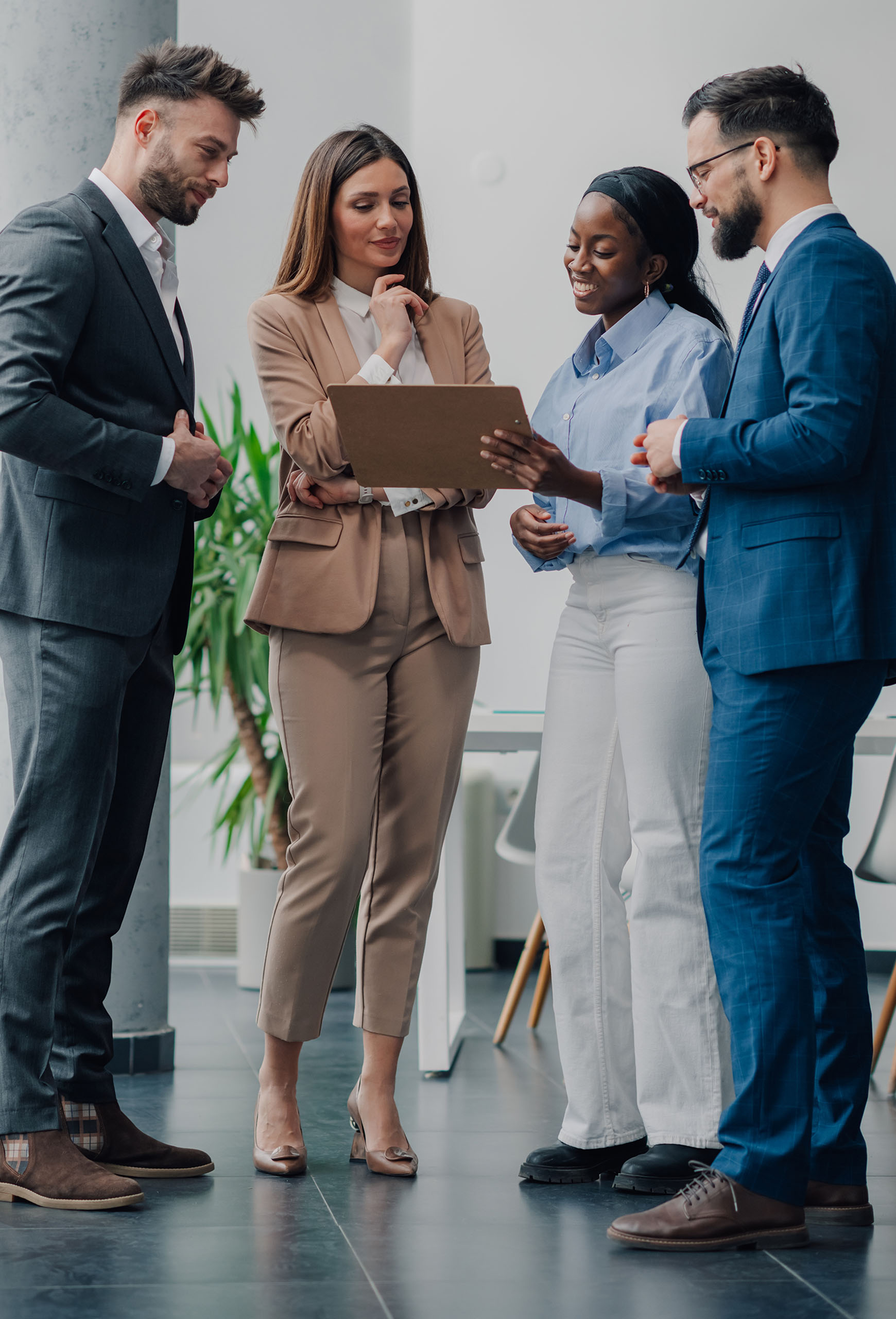 Four,Businesspeople,Are,Standing,Together,In,A,Modern,Office,,Collaborating